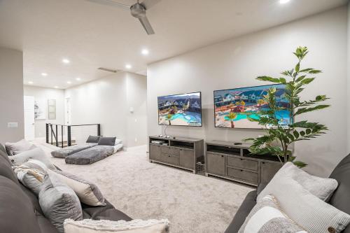 a living room with two couches and a flat screen tv at 30-31| 2 Homes in St George with Private Pools and Hot Tubs in Santa Clara