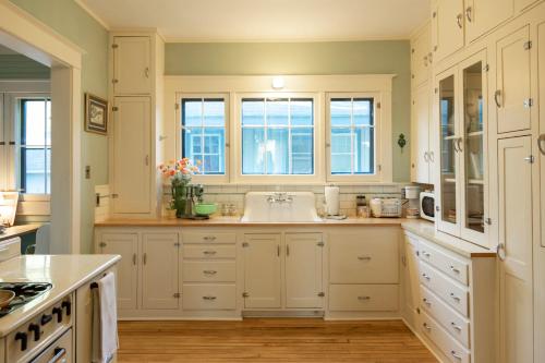 a kitchen with white cabinets and a sink at The Historic Benham-Johnston Bungalow in Sheridan
