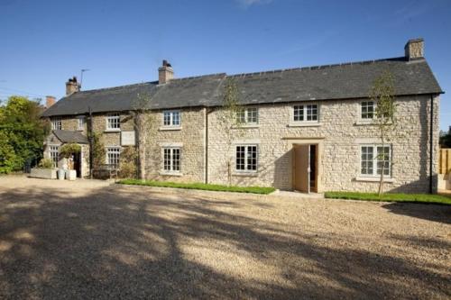 a large stone house with a large driveway at Finch's Arms in Oakham