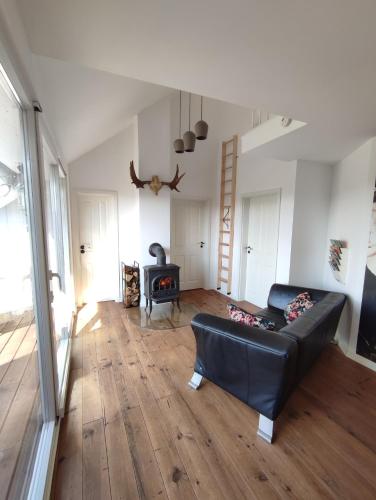 a living room with a black leather couch and a fireplace at Apartment 58- Ruhr Nah in Essen