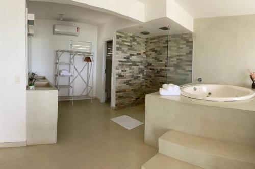 a bathroom with a tub and a walk in shower at Apartamento Natureza Pipa Privilege in Pipa
