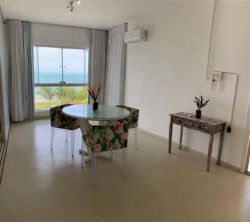 a dining room with a table and chairs and a window at Apartamento Natureza Pipa Privilege in Pipa