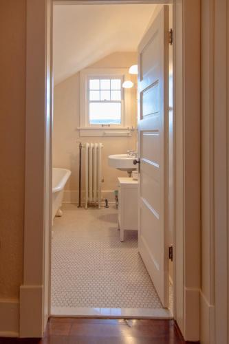 a bathroom with a sink and a tub and a toilet at The Historic Benham-Johnston Bungalow in Sheridan