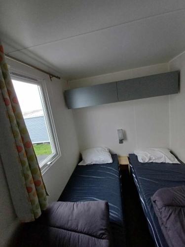 deux lits dans une petite pièce avec une fenêtre dans l'établissement Dépaysement sur Le Portel, à Le Portel