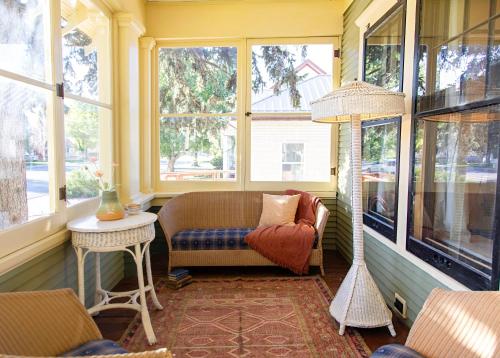 a room with a couch and a table and windows at The Historic Benham-Johnston Bungalow in Sheridan
