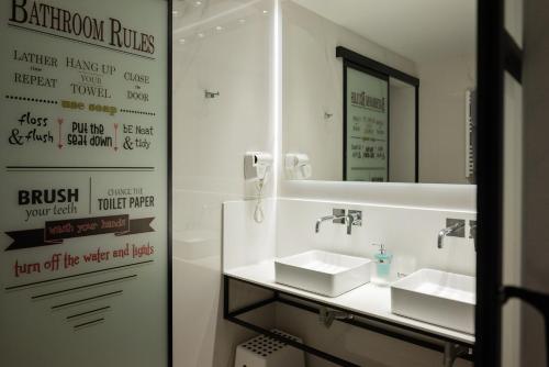 a bathroom with two sinks and a mirror at Kastro Hotel in Heraklio Town