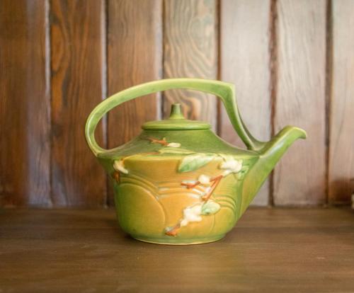 a green vase sitting on a wooden floor at The Historic Benham-Johnston Bungalow in Sheridan