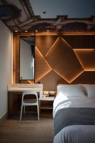 a bedroom with a bed and a desk and a mirror at Kastro Hotel in Heraklio Town