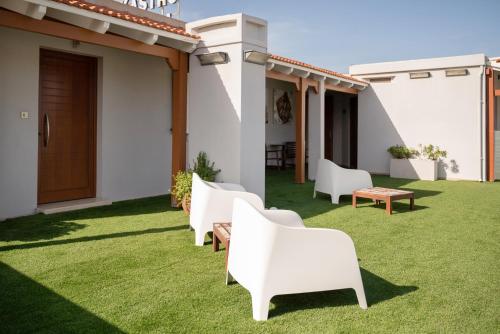 a row of white chairs on a lawn at Kastro Hotel in Heraklio Town