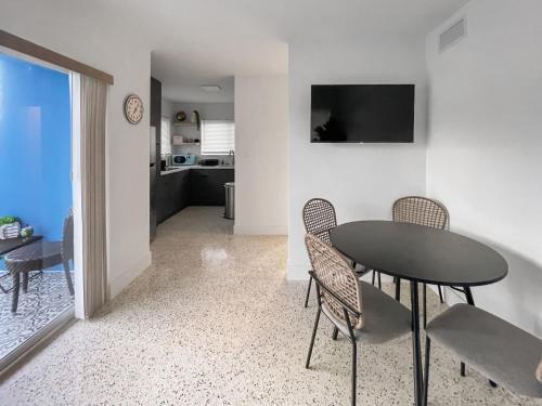 a dining room with a table and chairs and a kitchen at Newly Remodeled full Apartment in Miami