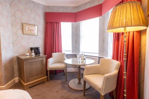 a room with a table and two chairs and a lamp at Best Western Plus The Connaught Hotel and Spa in Bournemouth
