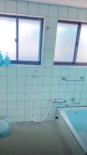 ein Badezimmer mit Dusche und Badewanne und Fenstern in der Unterkunft stone house in Bungotakada