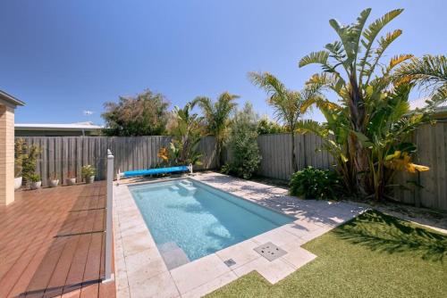 a swimming pool in a backyard with a fence at Zeally Sands Pool Retreat in Torquay