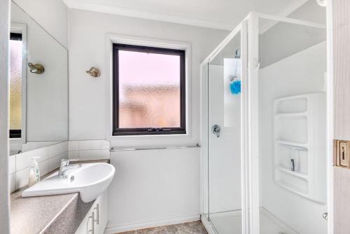 Un baño blanco con lavabo y ducha. en Family Moments, en Anglesea