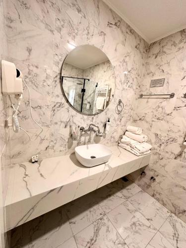 a white bathroom with a sink and a mirror at Hotel Wine Time Tbilisi in Tbilisi City