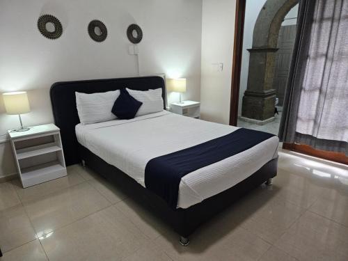 a bed in a bedroom with two tables and two lamps at Singular Coyoacán Pepper My Love! in Mexico City