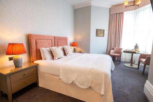 a bedroom with a large white bed and a table at Best Western Plus The Connaught Hotel and Spa in Bournemouth