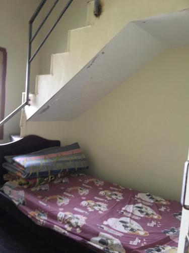 a bedroom with a bed and a stair case at jayaram Home in Chittoor