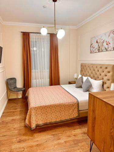 a bedroom with a bed and a chair and a window at Hotel Wine Time Tbilisi in Tbilisi City