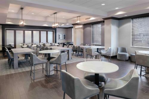 a dining room with tables and chairs and windows at Hampton Inn Lewiston-Auburn in Lewiston
