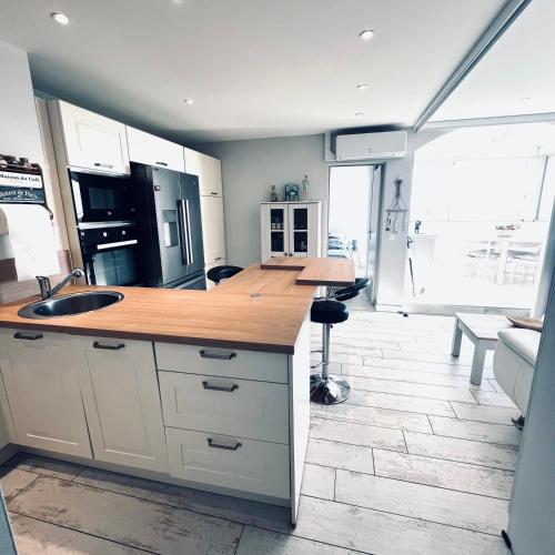 une cuisine avec un évier et un plan de travail dans l'établissement Le Soulairol Bleu, à Leucate