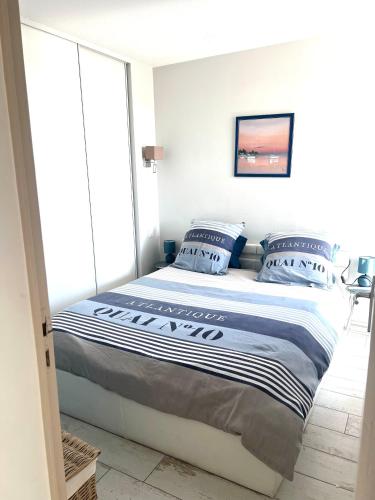 une chambre avec un grand lit avec des oreillers bleus dans l'établissement Le Soulairol Bleu, à Leucate