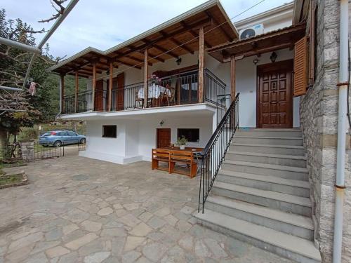 a house with a staircase and a balcony on it at Ellie Cottage Χαλάρωση στη Φύση in Ágios Nikólaos