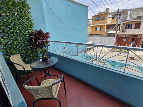 a balcony with two chairs and a table and a fence at Apartamento-Santa Anita, Villa Caly in Lima