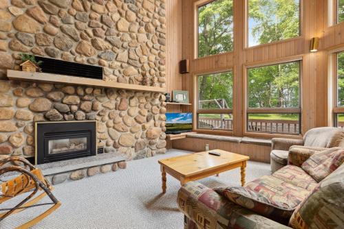 a living room with a stone wall and a fireplace at Causeway On Gull Resort in Lake Shore