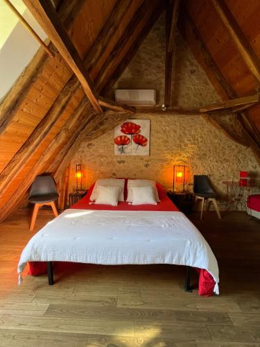 une chambre avec un grand lit dans un grenier dans l'établissement Chambre d'hôtes La Ferme de la Croix., à Saint-Avit-Sénieur