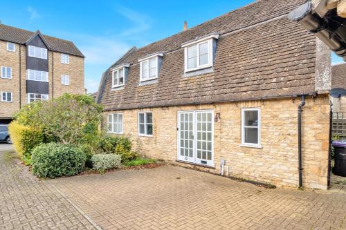 a brick house with white windows and a driveway at Lambert Cottage - In the Heart of Stamford in Stamford