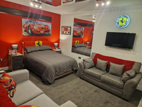 a bedroom with a bed and a couch and a tv at Joiners Arms - Studio Apartments in Market Drayton