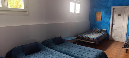 a room with a bed and a couch and a chair at Hostal A La Sombra Del Laurel in Navarrete