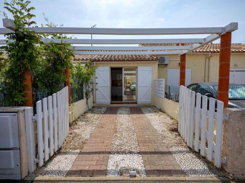 une clôture blanche devant une maison dans l'établissement Charmante maison proche plage, à Saint-Cyprien