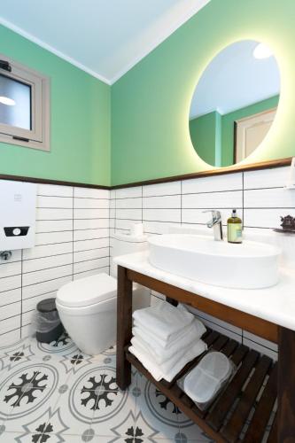 a bathroom with a sink and a toilet and a mirror at Urla Köstem Müze Otel in Uzunkuyu