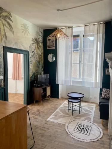 a living room with a table and a chair in it at Appart centre historique Tulle in Tulle