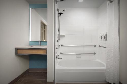 a bathroom with a bath tub and a sink at Hilton Garden Inn Colorado Springs North in Colorado Springs