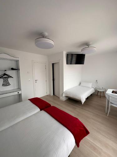 a bedroom with a bed with a red blanket on it at Hostal A La Sombra Del Laurel in Navarrete
