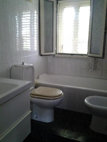a bathroom with a toilet and a tub and a sink at Appartamento Arenella in Arenella