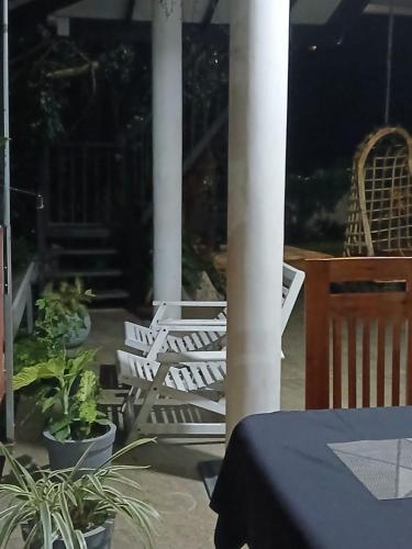a patio with a table and chairs on a porch at Kandyan Lounge in Kiribatkumbura