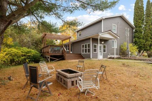 a backyard with chairs and a fire pit in front of a house at Long Lake Escape, Modern 3 Bedroom, Lower Unit of Duplex Home, Minutes to Downtown Traverse in Traverse City