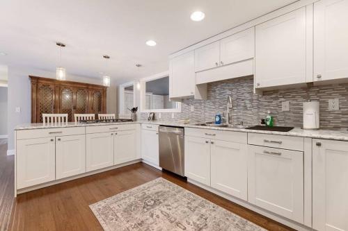 a kitchen with white cabinets and a brick wall at Long Lake Escape, Modern 3 Bedroom, Lower Unit of Duplex Home, Minutes to Downtown Traverse in Traverse City