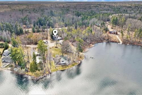 an aerial view of a house on an island in the water at Long Lake Escape, Modern 3 Bedroom, Lower Unit of Duplex Home, Minutes to Downtown Traverse in Traverse City