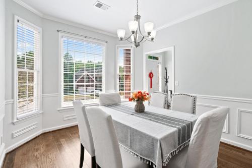 une salle à manger blanche avec une table et des chaises dans l'établissement Relaxing home close Six Flag 21 miles to airport, à Mableton