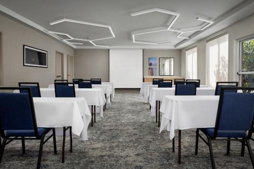 a conference room with white tables and blue chairs at Hilton Garden Inn Colorado Springs North in Colorado Springs