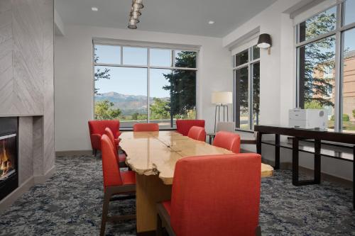 a dining room with a table and chairs and a fireplace at Hilton Garden Inn Colorado Springs North in Colorado Springs