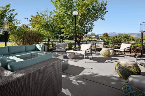 a patio with a couch and chairs and trees at Hilton Garden Inn Colorado Springs North in Colorado Springs