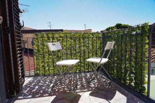 two chairs sitting on a balcony with a fence at R-HOME Li Cuti in Catania