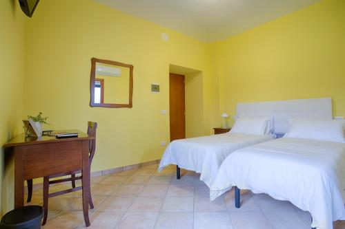 a bedroom with two beds and a desk and a mirror at Fons Clara Domus et Eventi in Fontechiari