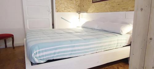 a bed with white sheets and pillows in a room at Residenza BiblioSosta in Ventimiglia